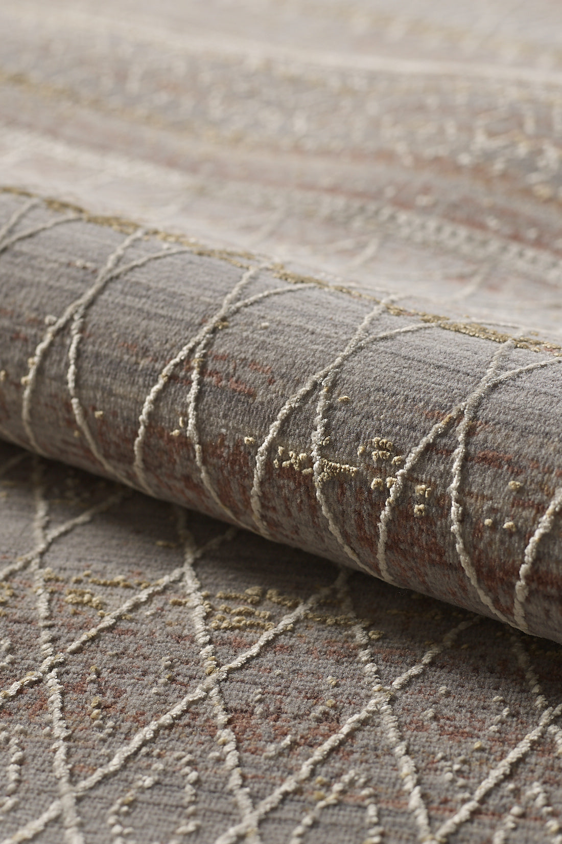 A close-up of the Sunkissed Boho Trellis Rug - M627M shows its machine-made gray base, white and beige geometric patterns, brown accents, and textured raised stitching, highlighting this modern neutral design.