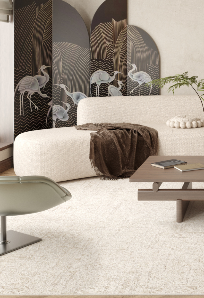 A modern living room features a white curved sofa, brown throw, wood coffee table with books, light swivel chair, and a crane folding screen—all anchored by the Sunset Fade - Washable Rug - JR1878, ideal for high-traffic areas.