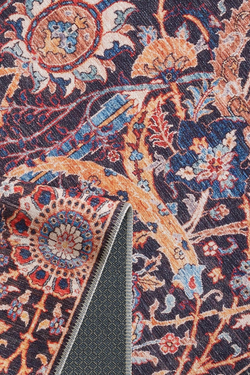 Bild 1 in Galerieansicht laden. A close-up of the Sylvanor Colorful Washable Rug - LCC3017 shows intricate blue, orange, and red floral and geometric patterns with a folded corner revealing its textured underside—ideal for high-traffic spaces.