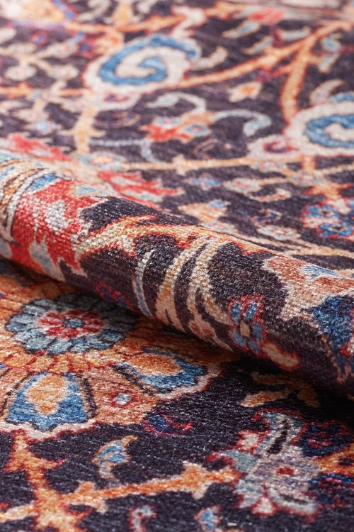 Bild 1 in Galerieansicht laden. A close-up of the Sylvanor Colorful Washable Rug - LCC3017, showing its detailed blue, red, yellow, and cream floral patterns on a dark background. The visible texture makes it perfect for high-traffic areas.