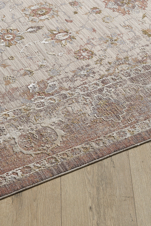 Bild 1 in Galerieansicht laden. The Timeless Petals Oushak Rug - Sand - M621N features floral designs in muted beige, pink, and gray on a viscose-polyester blend. This machine-made rug has a distressed, vintage look and is displayed on a light wood floor.