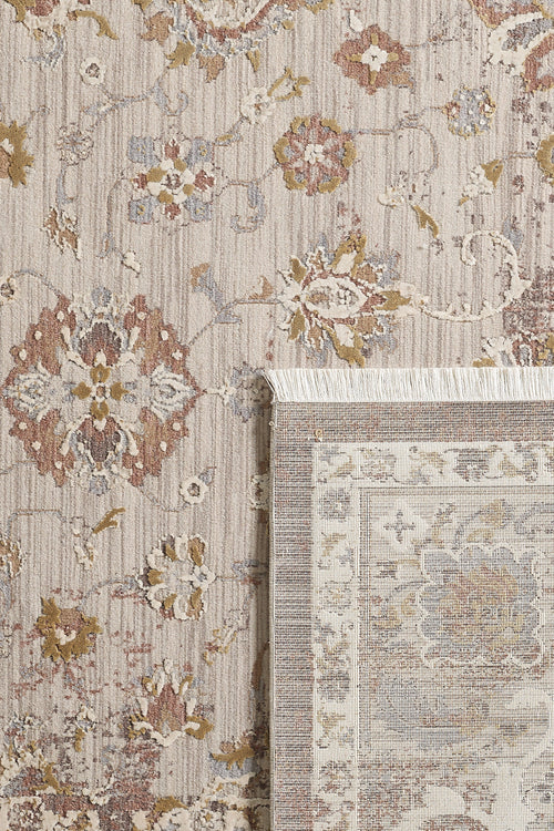 Bild 1 in Galerieansicht laden. A close-up of the Timeless Petals Oushak Rug - Sand (M621N) shows its beige, brown, and muted gold floral patterns, with one corner flipped to reveal the fringe and backing.