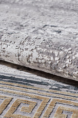 A close-up of the Timeless Remix Bordered Rug - Beige - MT187, a machine-made rug with abstract grey and white patterns and a yellow and grey Greek key border.