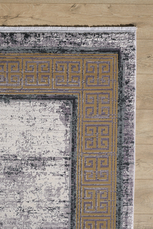 Load image 1 in gallery view. A close-up of the Timeless Remix Bordered Rug - Beige - MT187 on a wooden floor, featuring a gold and purple Greek key border and a distressed abstract gray and white main area.