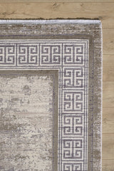 A corner of the Timeless Remix Bordered Rug - Cream - MT189, featuring a distressed, textured acrylic-viscose design in cream and gray tones, is shown on a light wooden floor.
