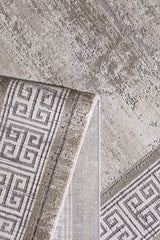 A close-up of the Timeless Remix Bordered Rug - Cream - MT189 shows a folded corner revealing its geometric Greek key design and textured, high-quality acrylic-viscose surface on both sides.