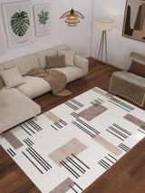 A modern living room with a beige sectional, neutral pillows, woven armchair, floor lamp, framed botanical prints, and the Timeless Scroll - Washable Rug - JRN45—ideal for contemporary style and high-traffic spaces.