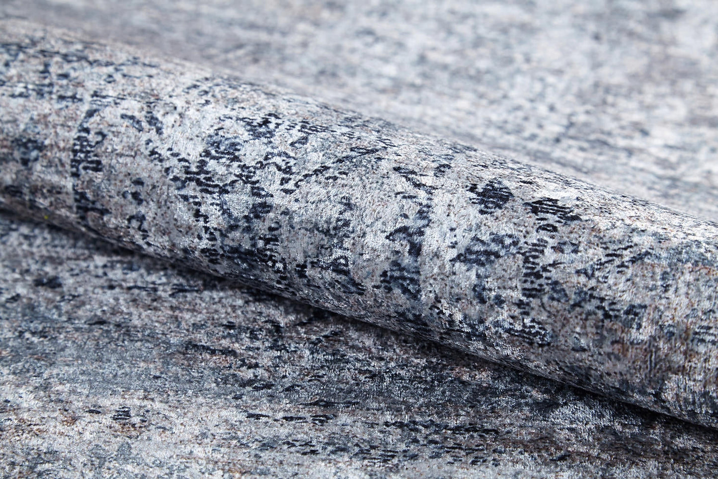 A close-up of the Timeless Scrollwork - Washable Rug - JR1774 (Custom Size) shows its textured, stone-like gray and black pattern, highlighting its durable design ideal for high-traffic areas.