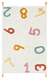 The Tiny Joy - Washable Shaggy - CBN02 is a rectangular white kids’ room rug with colorful numbers 0-9 in red, yellow, pink, and teal scattered across it and small yellow tassels on each corner for extra charm.