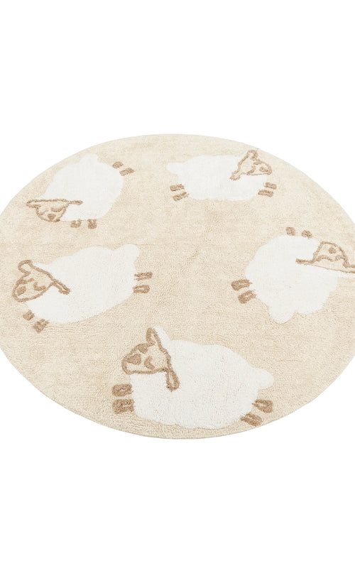 Load image 1 in gallery view. The Tiny Motion - Washable Shaggy - CBN11 is a round beige cotton shag rug with five white cartoon sheep featuring brown faces, ears, legs, and tails, evenly spaced around the design.