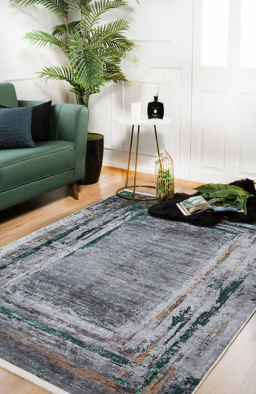 Load image 1 in gallery view. A modern living room with a green sofa, the JR1543 Traditional and Classic Washable Rug in gray, a round white side table with gold legs, potted plant, and decor. Light wood floors and white walls provide a bright, airy backdrop.