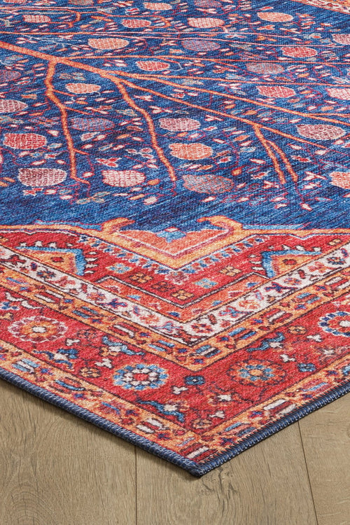 Load image 1 in gallery view. The Tree of Plenty Red Blue Washable Rug - LCC3031 boasts intricate blue, red, orange, and pink floral and geometric patterns, making it ideal for high-traffic areas. Shown on a light wood floor.