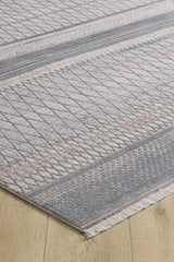A close-up of the Tribal Essence Trellis Rug - HRD005 shows its modern geometric patterns in gray and beige on a wooden floor. This machine-made rug features edge tassels for added texture.