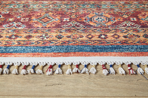 Load image 1 in gallery view. A close-up of the Tropic Thunder - Washable Rug - JR5077 (Custom Size) shows its allergy-friendly, vibrant multicolor geometric design with tassels, placed on a light wooden floor—perfect for adding style to any space.