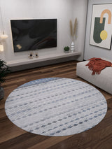 A modern living room with the Bohemian Reverie - Washable Rug - JR1974 in gray-anthracite on wooden floors, a wall-mounted TV, abstract art, plants, and a beige couch with an orange throw—ideal for high-traffic areas.