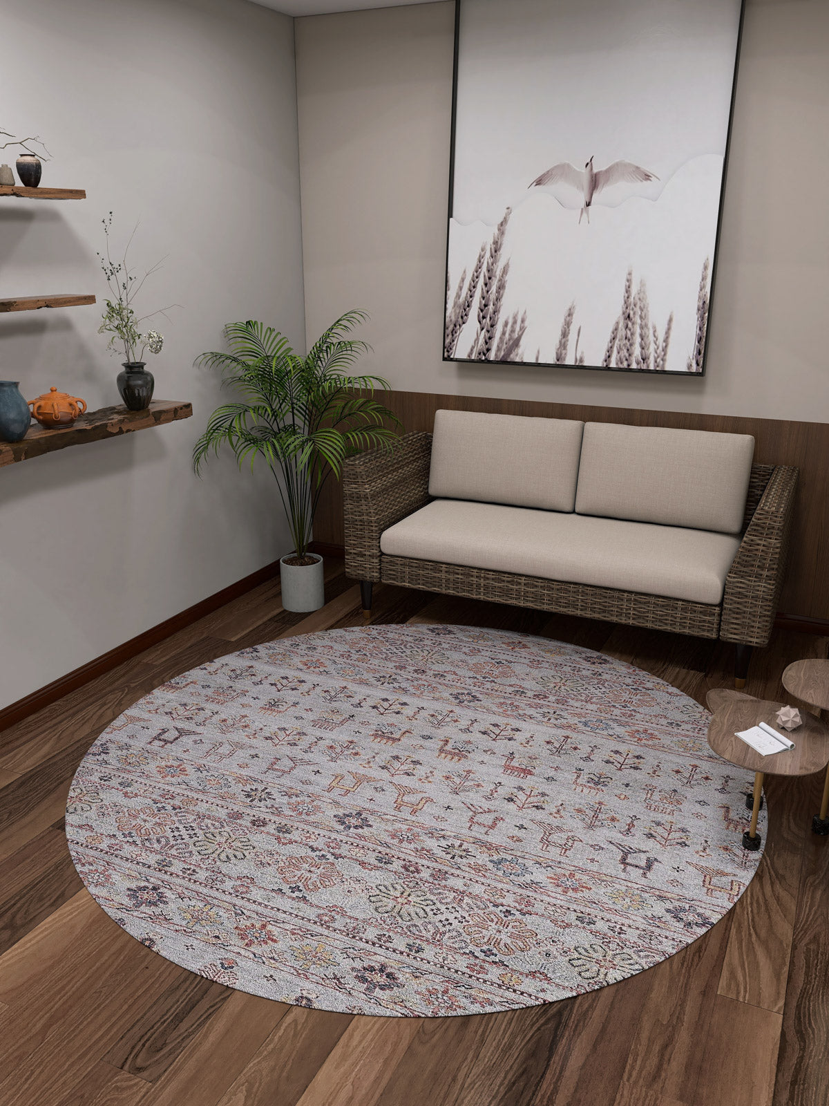 A cozy room with a wicker sofa, beige cushions, and the Nomad's Nest - Washable Rug - JR5088—ideal for high-traffic areas—plus a small wooden table, potted plant, wall shelves with decor, and large bird-themed artwork.