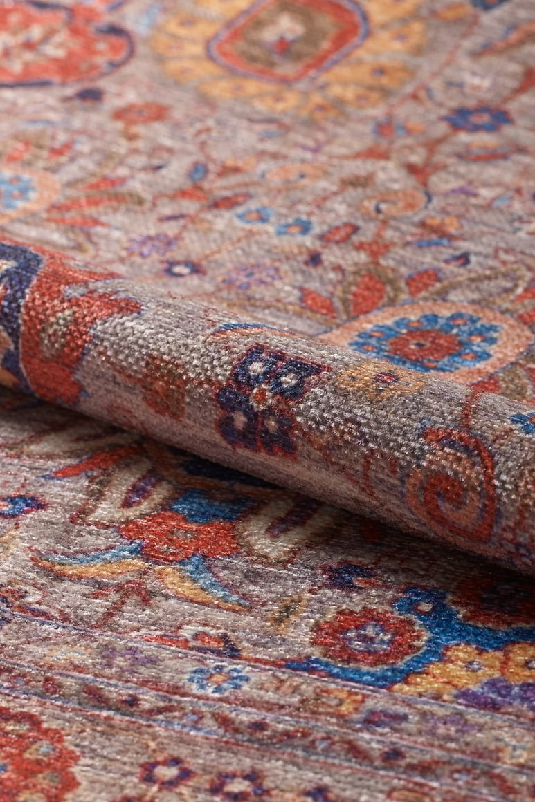 A close-up of the Velorio Floral Washable Rug - LCC3006 (Custom Size) shows its intricate floral and geometric patterns in red, blue, orange, and beige. The rug's textured weave is ideal for high-traffic areas and is clearly visible.