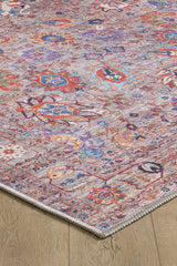 A close-up of the Velorio Floral Washable Rug - LCC3006 (Custom Size) showcasing intricate red, blue, purple, and orange patterns on light beige—ideal for allergy-sensitive homes and high-traffic areas, placed on a wooden floor.