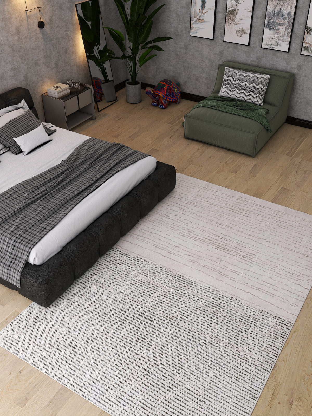 A modern bedroom with a low black bed, gray bedding, green lounge chair, large plant, wall art, and the Velvet Echo - Washable Rug - JRN25 (Custom Size), perfect for high-traffic wooden floors. A colorful elephant decor piece is by the chair.