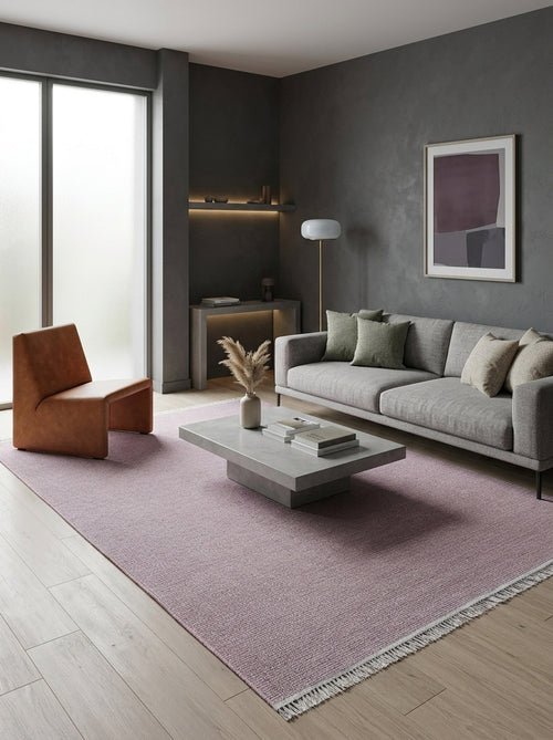 Load image 1 in gallery view. Minimalist living room with gray walls, modern gray sofa, light brown accent chair, concrete coffee table on a Velvet Touch Pink Area Rug - PST005, decorative vase, floor lamp, wall art, and sunlight through frosted windows.