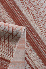 A close-up of the Vibrant Bohemian Trellis Rug - HRD009 shows its machine-made geometric patterns in rust red and cream, with a folded corner. Diamonds, triangles, and lines create a modern yet timeless look.