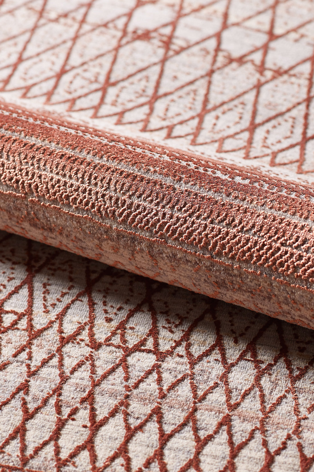 A close-up of the Vibrant Bohemian Trellis Rug - HRD009 shows its intricate rust red geometric and lattice pattern on a light beige viscose-polyester background, highlighting the woven material’s texture.