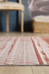A close-up of the Vibrant Bohemian Trellis Rug - HRD009, featuring a red and white pattern on a wooden floor, with a softly blurred background including part of a chair and woven basket.
