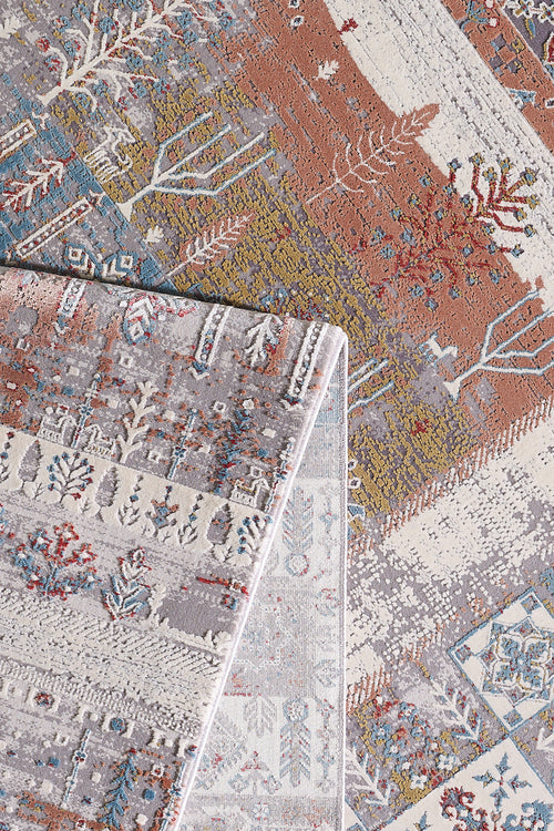 Load image 1 in gallery view. A close-up of two overlapping Vibrant Nomadica Premium Rug - M366C area rugs, showcasing machine-made nature-inspired patterns and traditional motifs in earthy browns, beiges, blues, and reds with branches, leaves, and geometric designs.