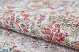 A close-up of the Vintage Cream - Machine-Washable Rug (JR5006, Custom Size) shows its rolled-up, textured surface with a faded floral pattern in red, green, gold, and black on a light background—ideal for high-traffic areas.