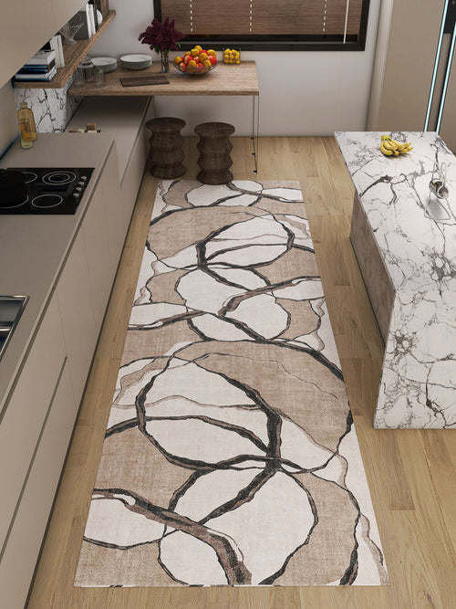 Load image 1 in gallery view. A modern kitchen with light wood floors, beige cabinets, and marble countertops features the Vintage Muse - Washable Rug - JRN47 (Custom Size), showcasing abstract brown and black circles. Allergy-friendly and stylish—perfect for busy homes.