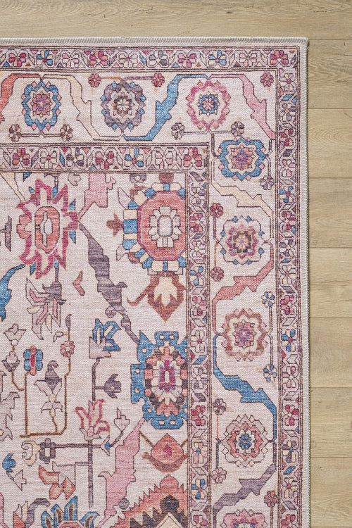 Load image 1 in gallery view. A close-up of the Vivencia Authentic Washable Rug - LCC3016 (Outlet) US, showcasing its durable construction and intricate pink, blue, and beige geometric and floral patterns on a light wooden floor.