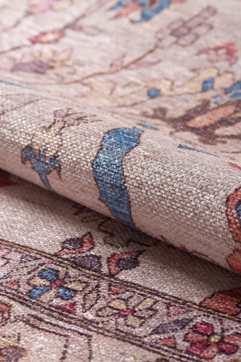 Close-up of the Vivencia Authentic Washable Rug - LCC3016 (Outlet) US in beige, blue, and pink with detailed woven floral designs. A folded cream and beige section highlights the rug’s durability, softness, and thickness.