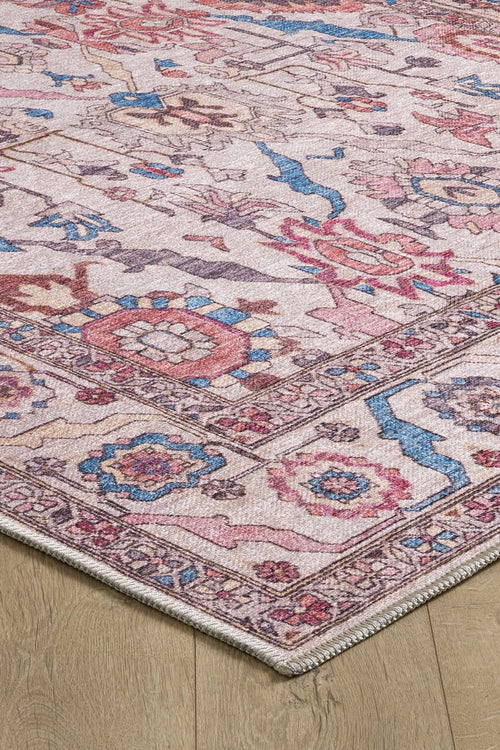 Load image 1 in gallery view. A close-up of the Vivencia Authentic Washable Rug - LCC3016 (Custom Size), featuring an intricate geometric and floral pattern in pink, blue, and beige—perfect for allergy-sensitive homes. Its cream/beige corner is displayed on a wooden floor.