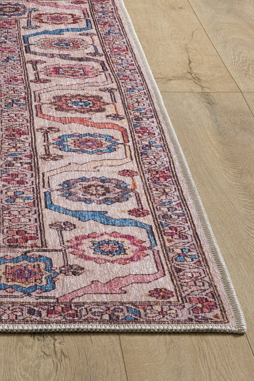 Load image 1 in gallery view. A close-up of the Vivencia Authentic Washable Rug - LCC3016 (Custom Size) with pink, blue, and beige intricate designs on a light wood floor. This allergy-friendly rug features a detailed border and visible edge stitching.