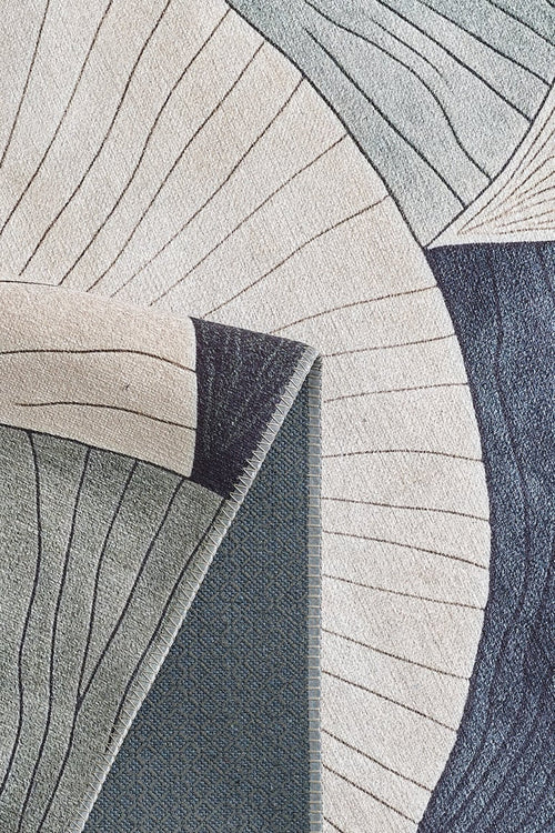 Load image 1 in gallery view. A close-up of the Vivian Modern Washable Area Rug - MDJ010 shows abstract, curved shapes in cream, blue, and gray. One corner is folded to reveal its textured backing—perfect for high-traffic or allergy-sensitive homes.