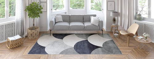 Load image 1 in gallery view. A modern living room featuring the Vivian Modern Washable Area Rug - MDJ010 (Custom Size), paired with a gray sofa, light wood chair, round coffee table, and potted plant—perfect for sunny spaces with parquet floors and high foot traffic.