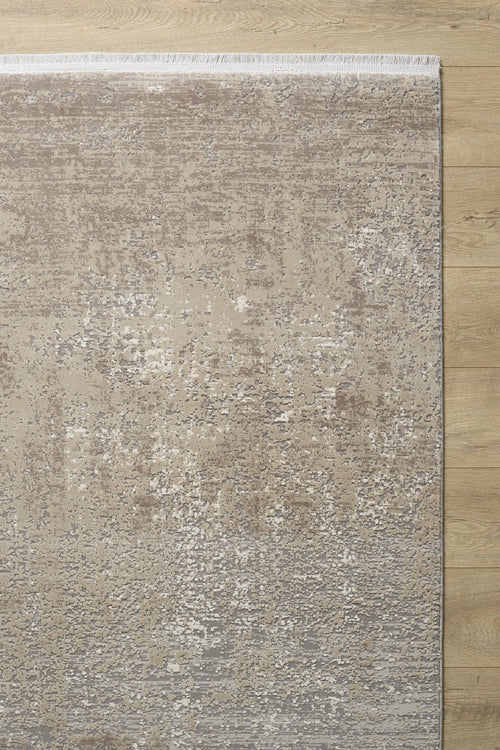 Load image 1 in gallery view. The Vortexia Light Premium Rug - M472D is a rectangular contemporary rug with a textured abstract pattern in neutral beige and taupe, featuring a subtle gradient, short fringe on one edge, and placed on a light wood floor.