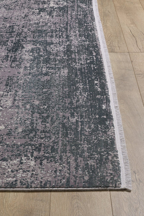 Load image 1 in gallery view. A close-up of the Vortexia Silver Premium Rug - M472A, showcasing its pixelated gray and lavender pattern on a light wood floor. The machine-made rug features a thin, light-colored border for a modern touch.
