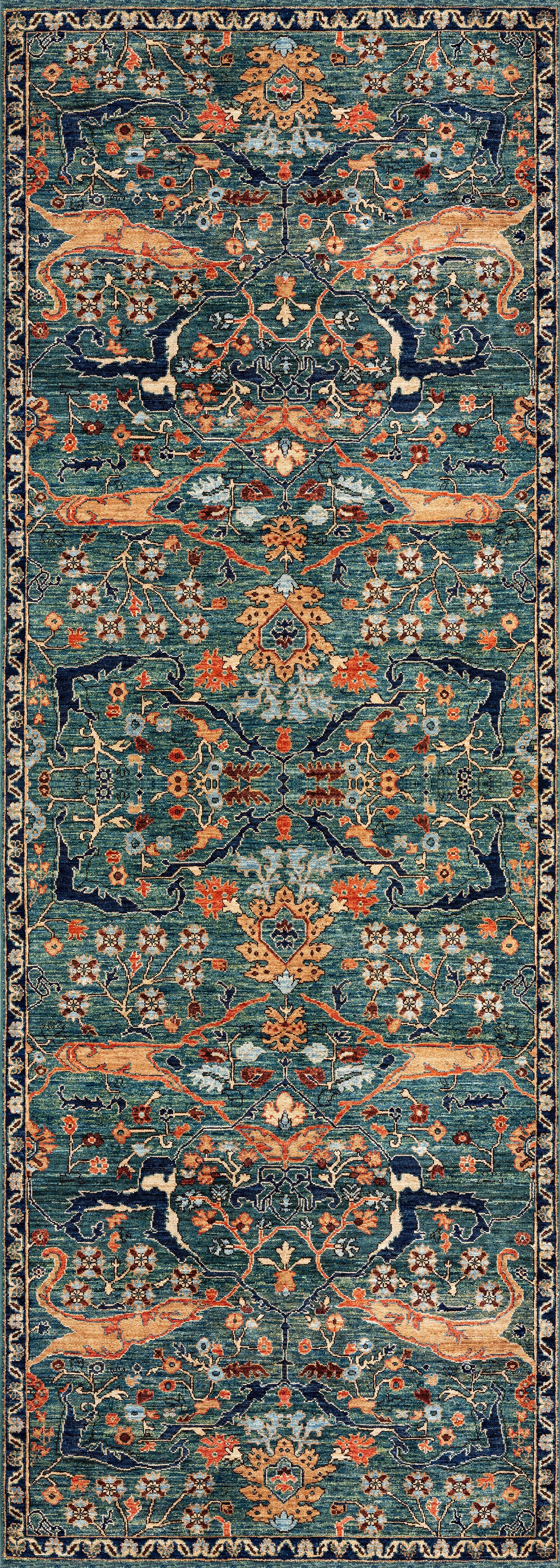 The Whisper Authentic Blue Washable Rug - LCC3034 is a rectangular, ornate blue rug with a symmetrical floral and vine pattern in blue, orange, gold, and beige, featuring a dark blue border—ideal for high-traffic areas.