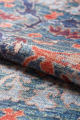 Close-up of the Whisper Authentic Blue Washable Rug - LCC3034 (Custom Size), featuring orange floral and leaf designs with detailed woven texture—ideal for high-traffic areas due to its durable, easy-to-clean construction and intricate patterns.