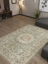 A living room with light wood floors, modern gray seating, plants, wall art, soft corner lamp lighting, and the Whispered Heritage - Washable Rug - JRN30: a large pale green Persian rug with a central floral medallion.