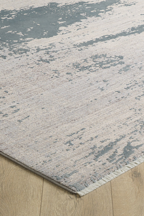 Load image 1 in gallery view. A close-up of the Whispering Mist Modern Rug - Silver (HRD002) shows its abstract beige pattern on a light wood floor. This machine-made rug has visible edging and a modern, slightly distressed, worn look.