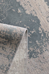 A close-up of the Whispering Mist Modern Rug - Silver (HRD002) shows its abstract, vintage-style pattern in muted gray and beige, with a folded corner revealing both the front design and underside.