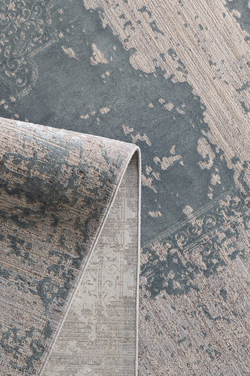 Load image 1 in gallery view. A close-up of the Whispering Mist Modern Rug - Silver (HRD002) shows its abstract, vintage-style pattern in muted gray and beige, with a folded corner revealing both the front design and underside.
