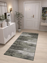 A modern hallway features a white front door, light wood floors, and the Wistful Pattern - Washable Rug - JRN35, ideal for high-traffic areas. A white sideboard with décor, potted plant, wall art, and floral arrangement on a floating shelf complete the look.