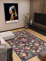 Modern living room featuring the Woven Grace - Washable Rug - JRN28, a sectional sofa, potted plant, wall-mounted TV, and a framed “Girl with a Pearl Earring” print displayed above the plant.