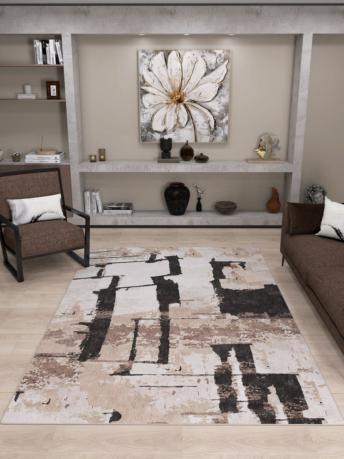 A modern living room with a brown chair and sofa, minimalist shelves with decor, a large white flower painting above the shelves, and the Woven Memoir - Washable Rug - JRN41 as a flat weave rug.