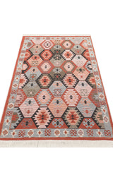 The Woven Spirit - Washable Double-Sided Kilims - AR42 is a rectangular kilim rug with a geometric hexagon pattern in red, orange, gray, and beige. It has a decorative border, fringed edges, and adds both style and versatility to any space.