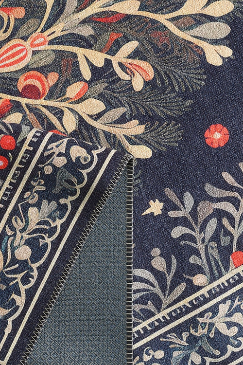 Load image 1 in gallery view. A close-up of the Xmas Tree Washable Area Rug - MDJ005, featuring a folded edge that reveals detailed stitching and the reverse side—its botanical red, orange, and cream design on navy blue is perfect for high-traffic spaces.