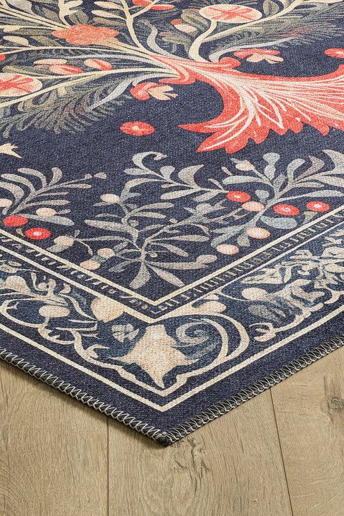Load image 1 in gallery view. Corner of the Xmas Tree Washable Area Rug - MDJ005, featuring a dark blue background, cream floral and vine patterns with red accents, and a detailed border, displayed on light wood flooring—ideal for high-traffic spaces.